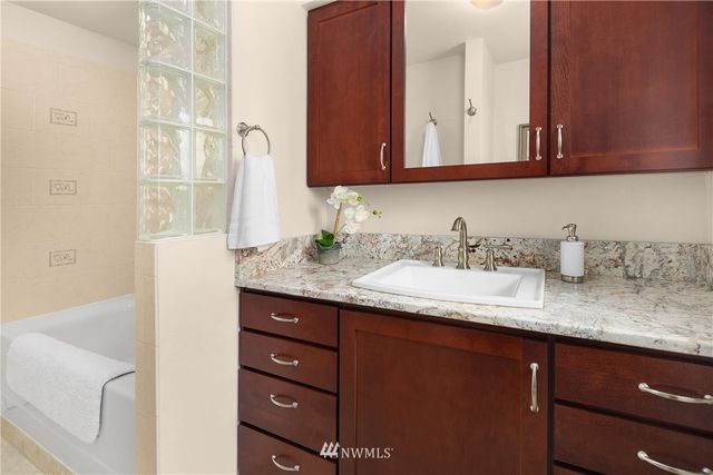 a bathroom with a granite countertop sink and a mirror