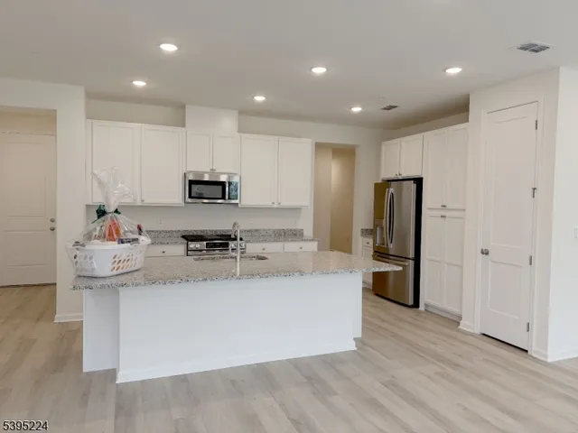 a view of kitchen with stainless steel appliances granite countertop a refrigerator stove top oven and sink