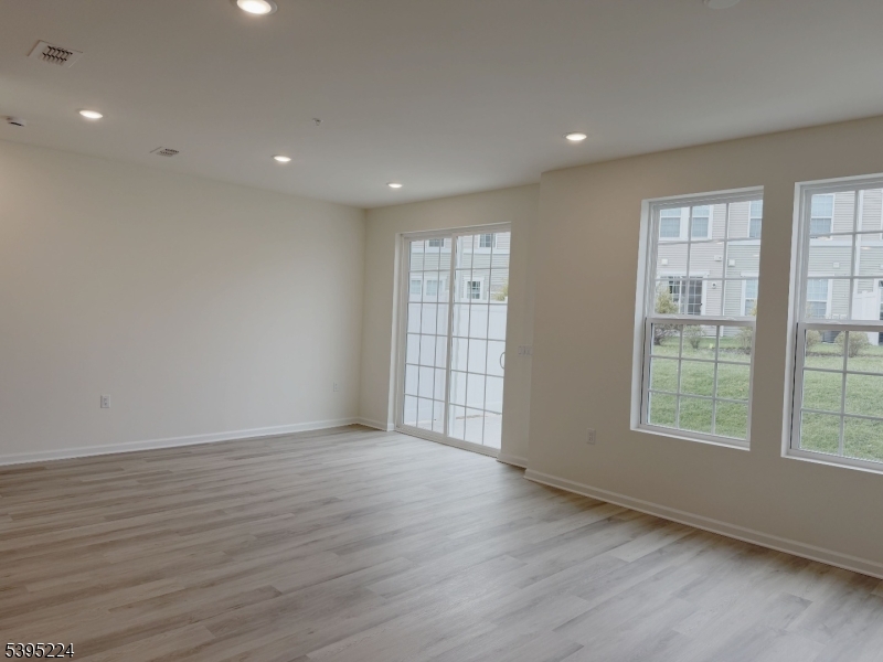 107 Myrtle Road Warren, NJ 07059 - Photo 4 of 12 an empty room with wooden floor and windows