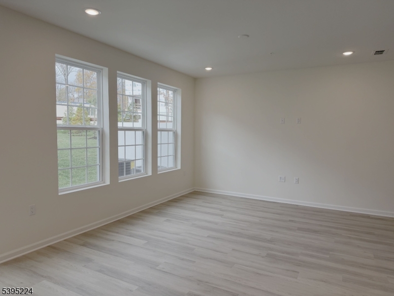107 Myrtle Road Warren, NJ 07059 - Photo 5 of 12 an empty room with wooden floor and windows