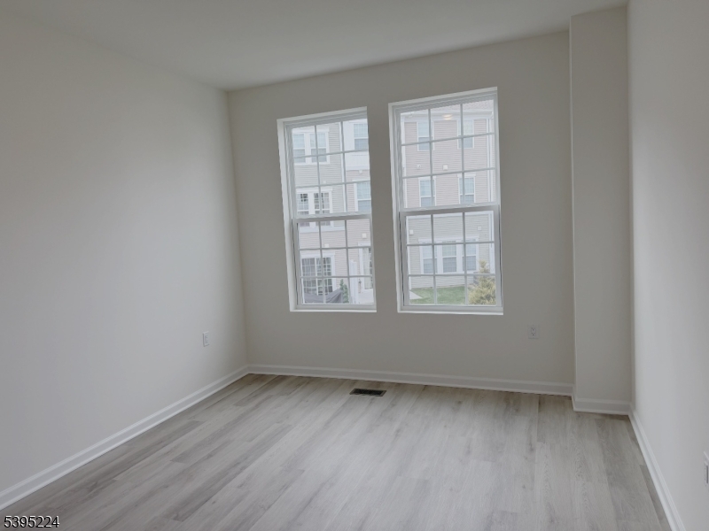 107 Myrtle Road Warren, NJ 07059 - Photo 9 of 12 an empty room with wooden floor and windows