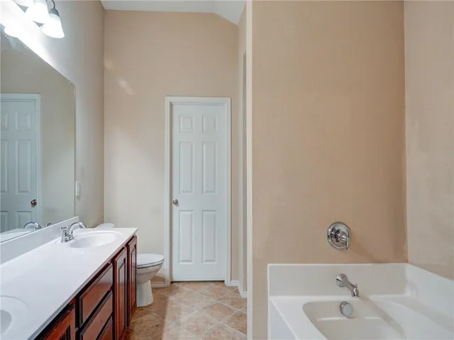 a bathroom with a tub sink and mirror