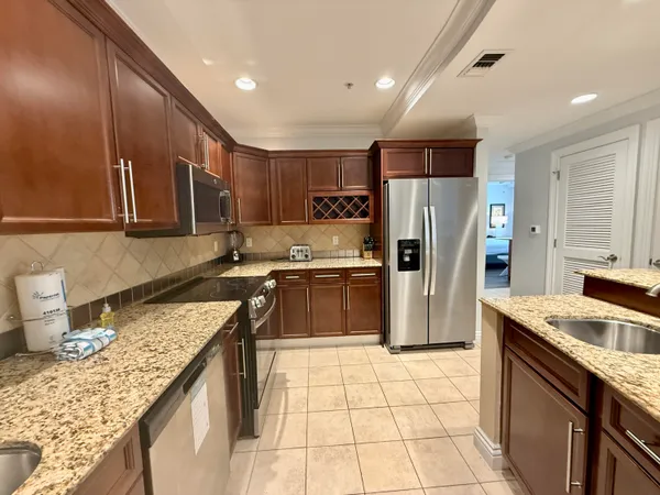 a kitchen with stainless steel appliances granite countertop a sink stove and refrigerator