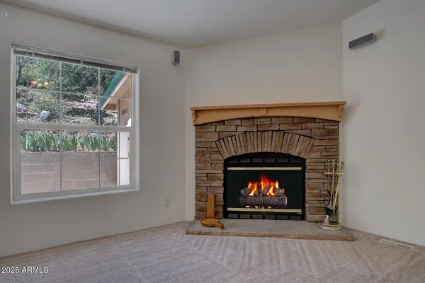 a view of empty room with a fireplace and a window