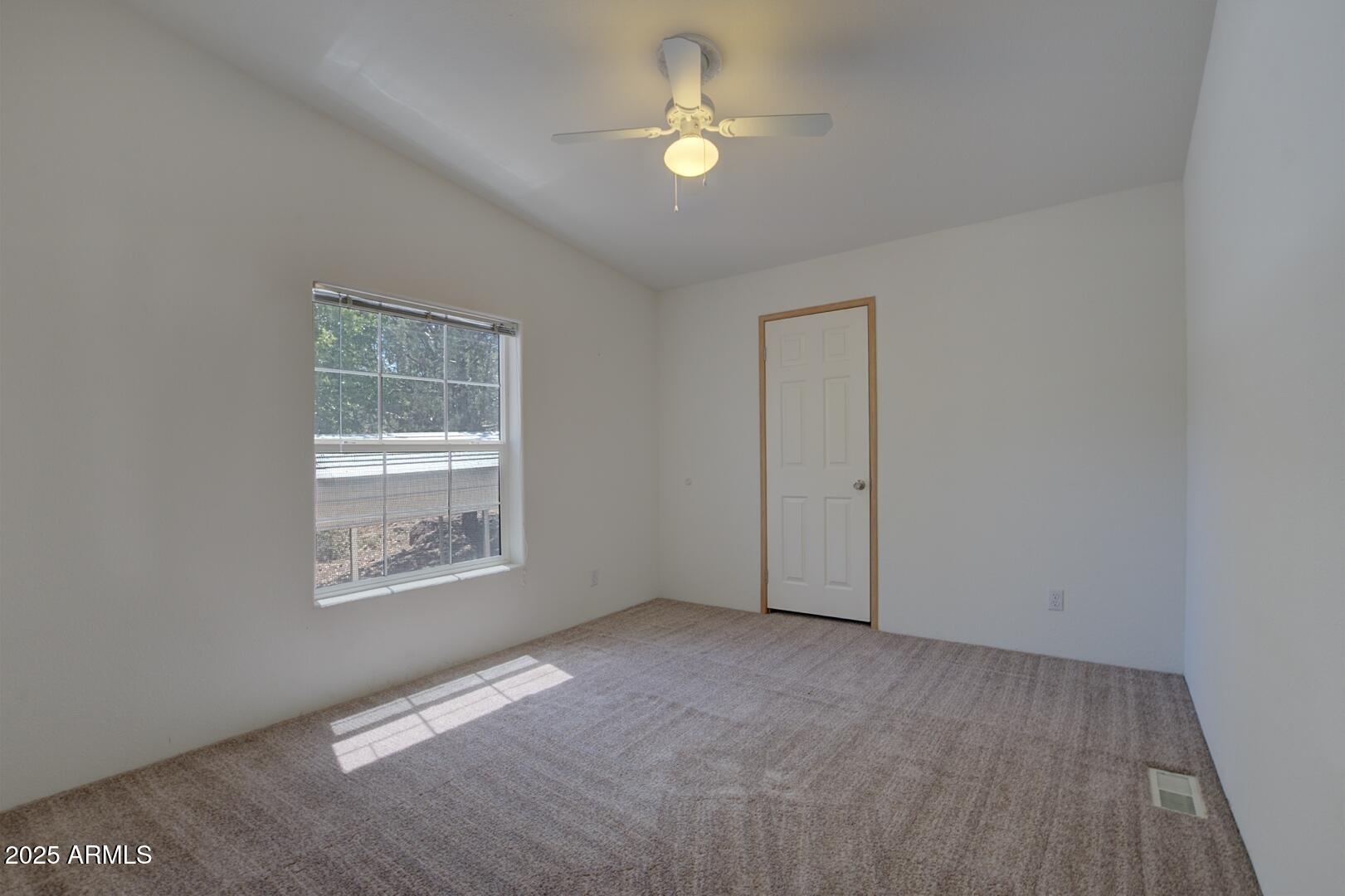405 East Cherry Street Payson, AZ 85541 - Photo 35 of 47 an empty room with chandelier fan and windows