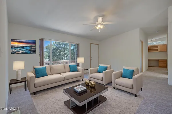 an empty room with a fan & a window