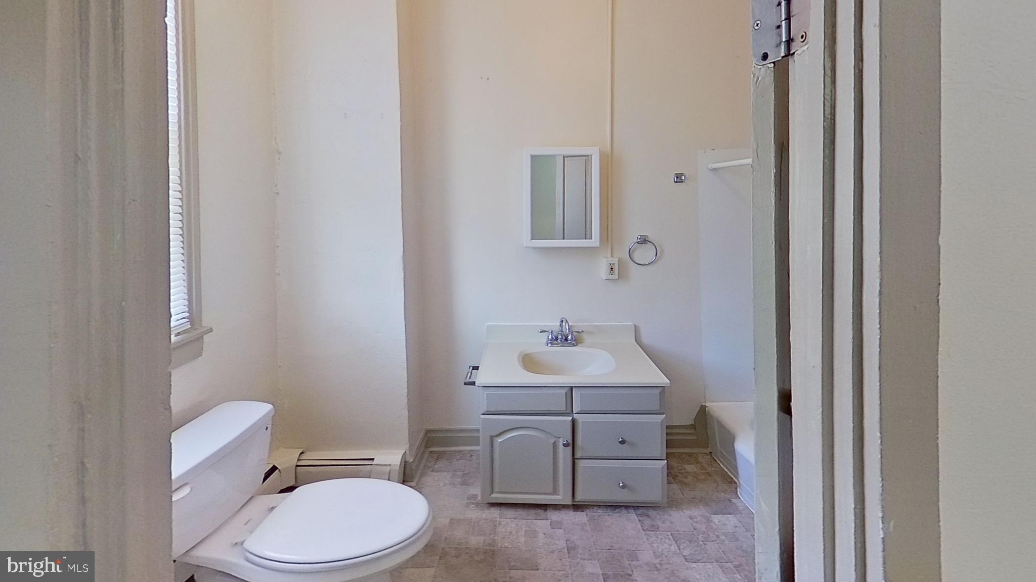 142 West Main Street, Unit C Windsor, PA 17366 - Photo 3 of 8 a bathroom with a toilet a sink and mirror