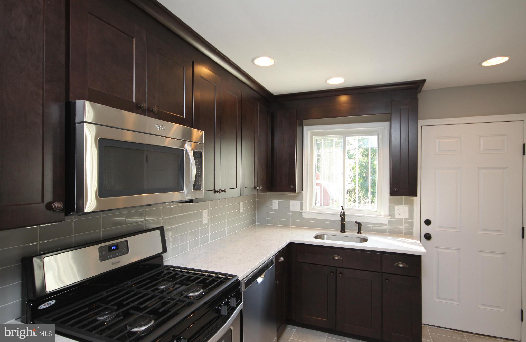 7103 Bexhill Road Baltimore, MD 21244 - Photo 1 of 30 a kitchen with wooden cabinets and a sink