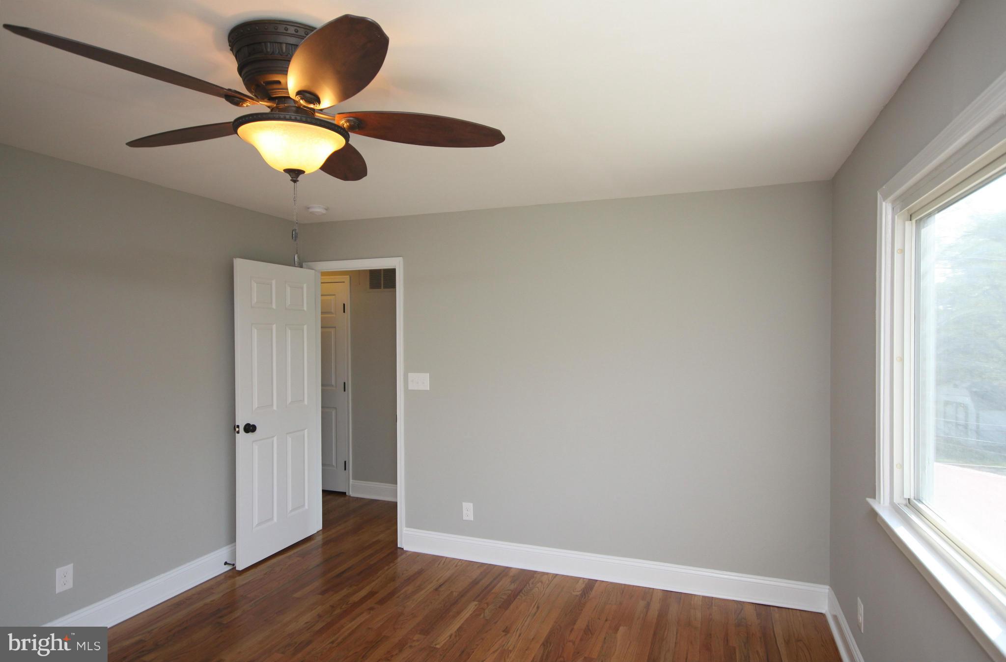 7103 Bexhill Road Baltimore, MD 21244 - Photo 12 of 30 a view of an empty room with wooden floor and a window
