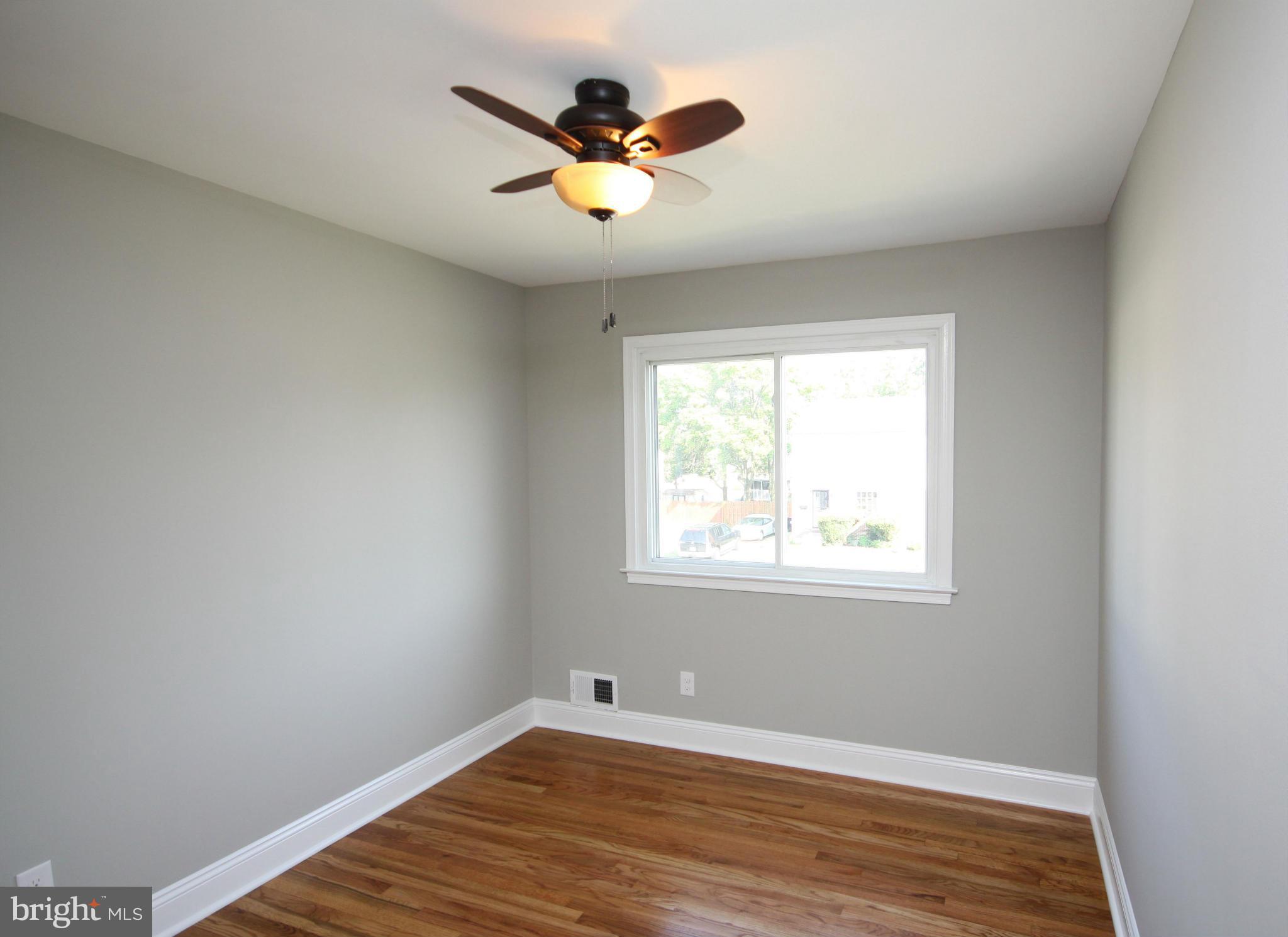 7103 Bexhill Road Baltimore, MD 21244 - Photo 16 of 30 a view of an empty room with wooden floor and a window