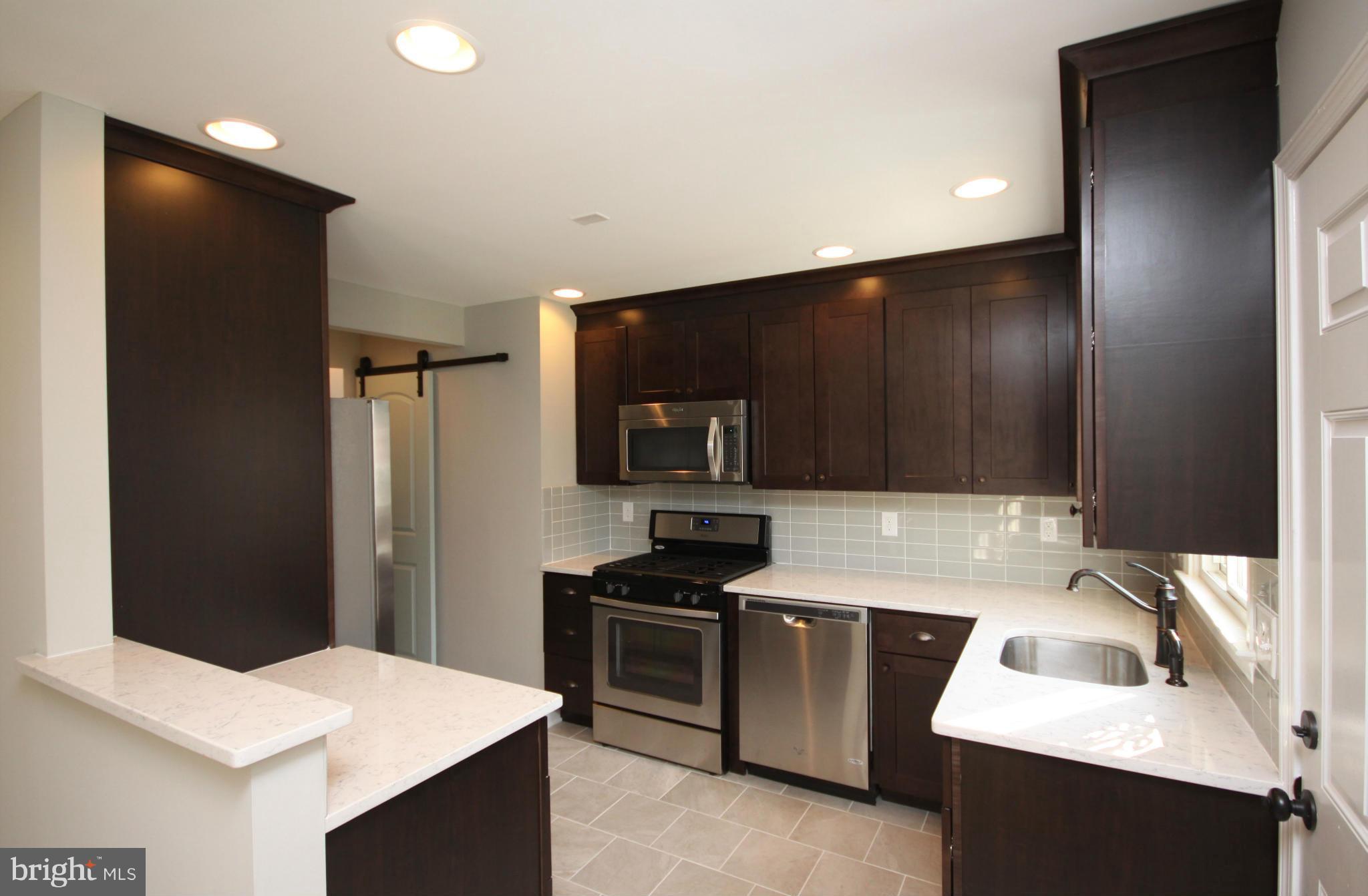 7103 Bexhill Road Baltimore, MD 21244 - Photo 3 of 30 a kitchen that has a sink stainless steel appliances a counter space and cabinets