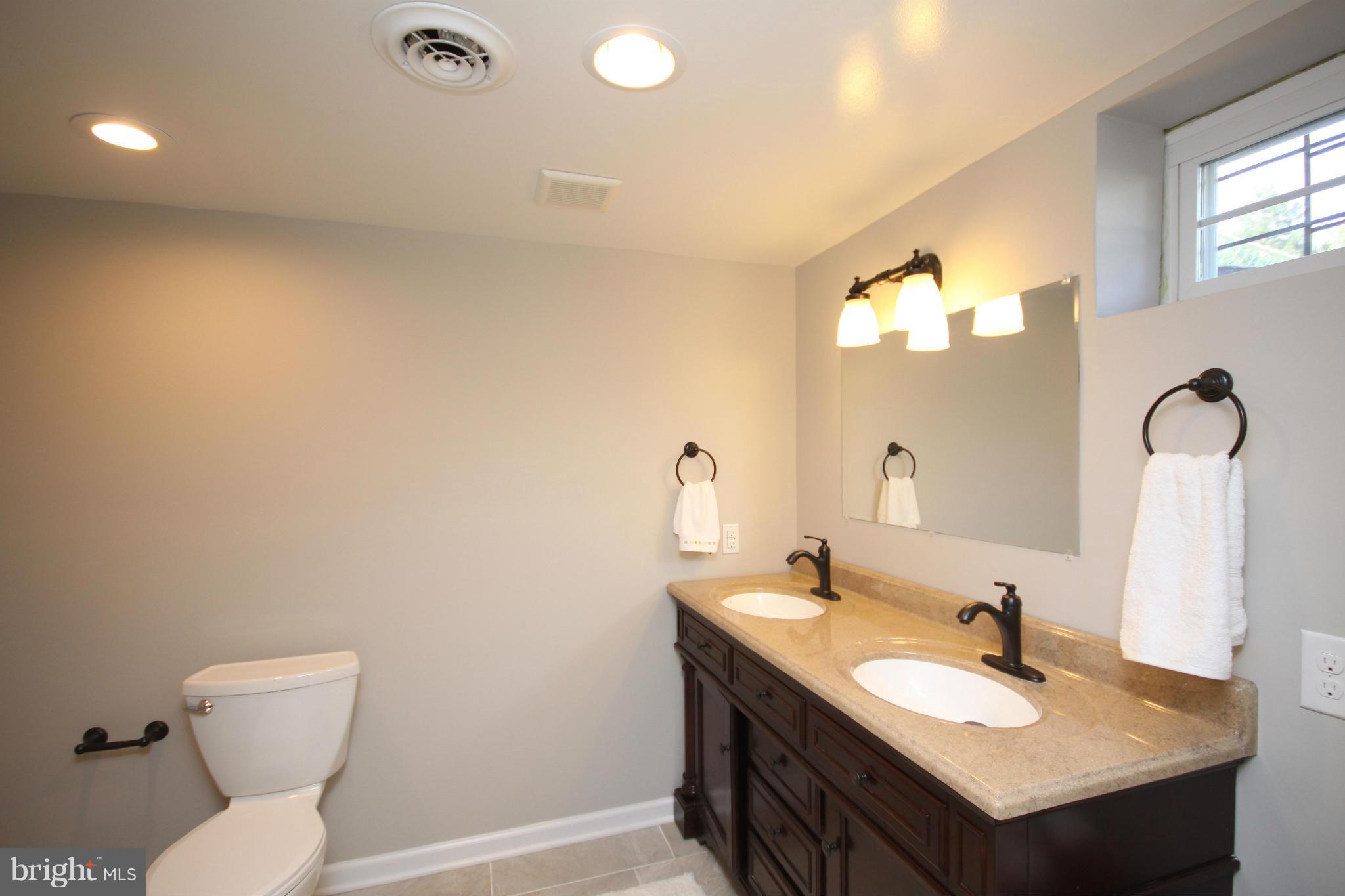 7103 Bexhill Road Baltimore, MD 21244 - Photo 22 of 30 a bathroom with a sink toilet and a mirror