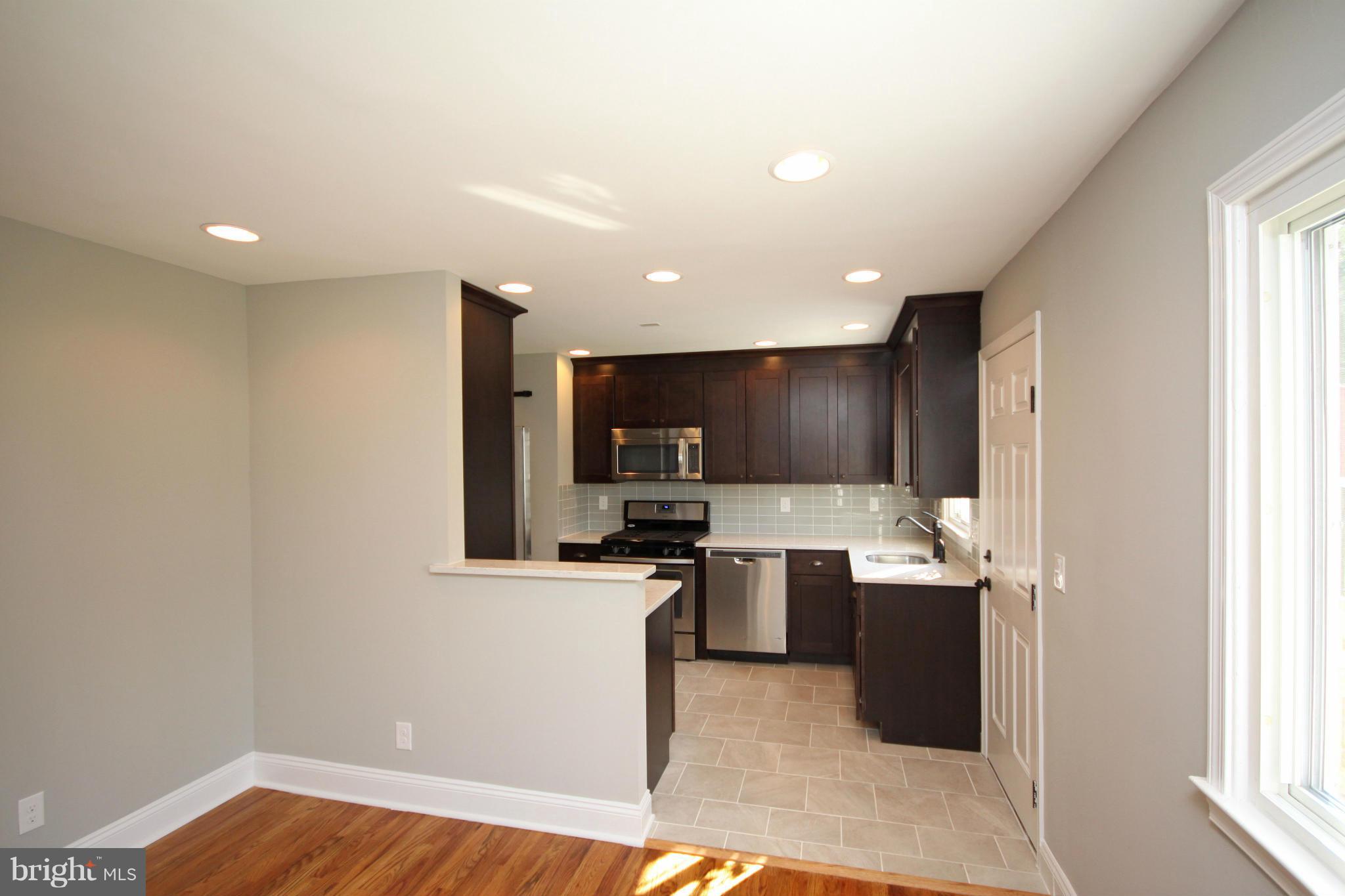 7103 Bexhill Road Baltimore, MD 21244 - Photo 6 of 30 a kitchen with stainless steel appliances granite countertop a sink and a microwave