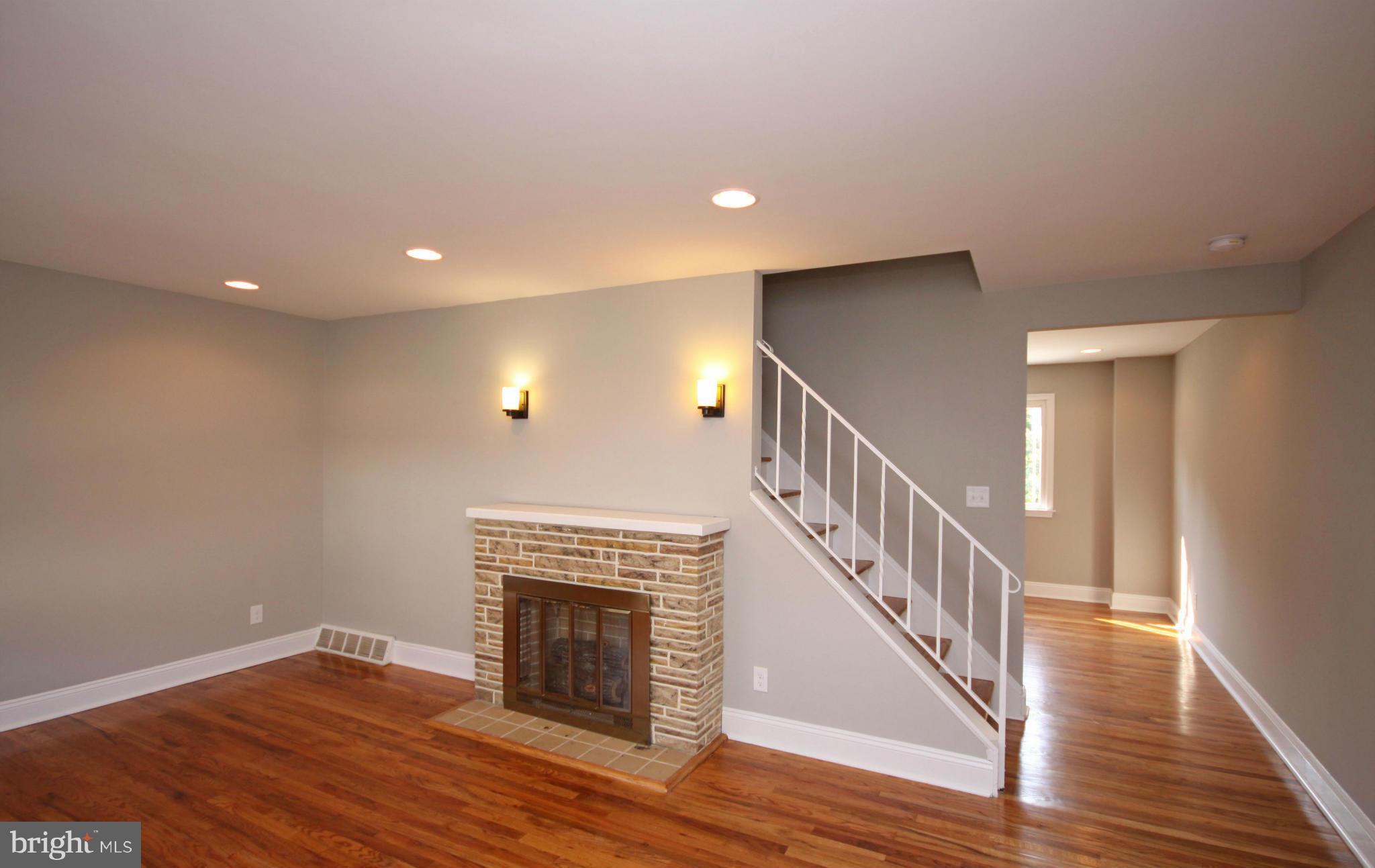 7103 Bexhill Road Baltimore, MD 21244 - Photo 9 of 30 a view of an empty room with wooden floor fireplace and a window