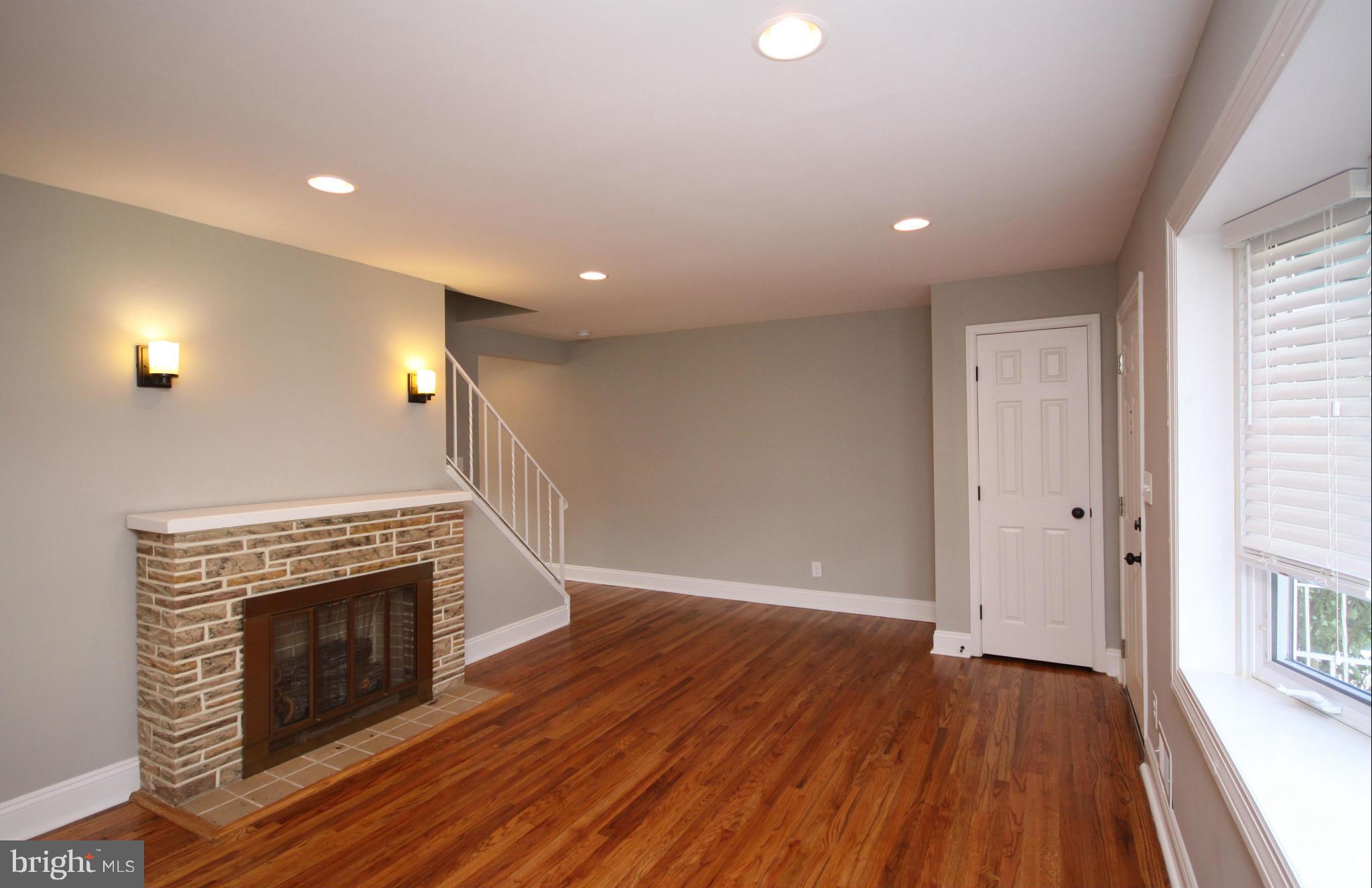 7103 Bexhill Road Baltimore, MD 21244 - Photo 10 of 30 a view of an empty room with wooden floor fireplace and a window