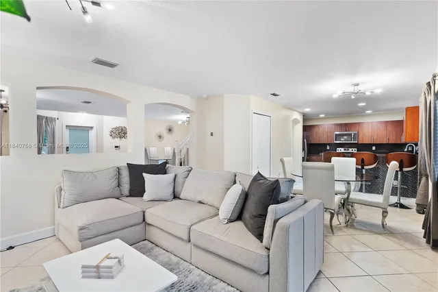 a living room with furniture and kitchen view