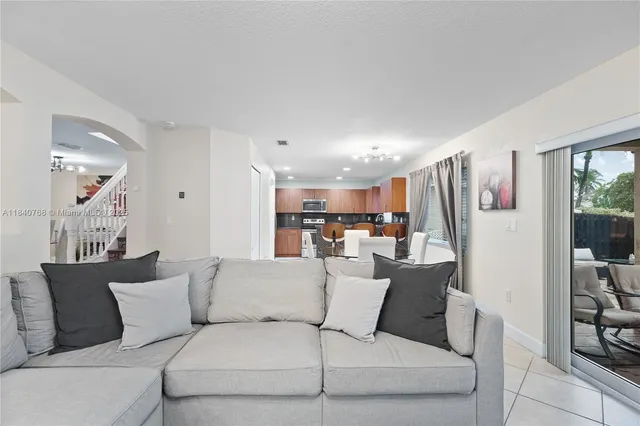 a living room with furniture and a dining table with wooden floor