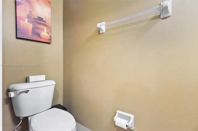 a white toilet sitting next to a white wall