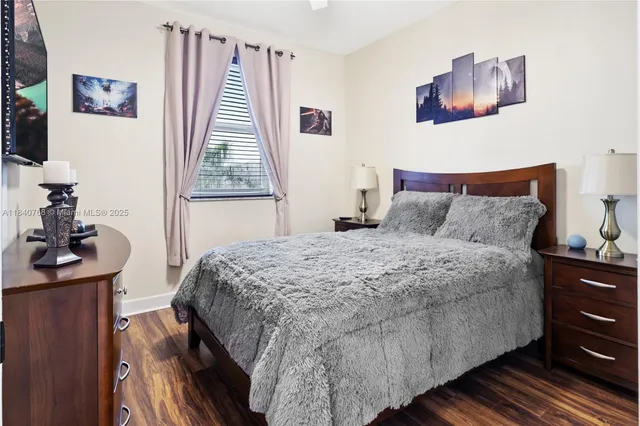 a bedroom with a bed and a lamp on dresser