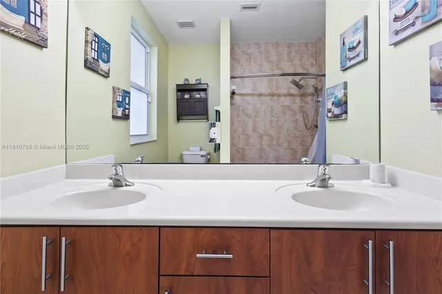 a bedroom with a bed and a flat tv screen on dresser