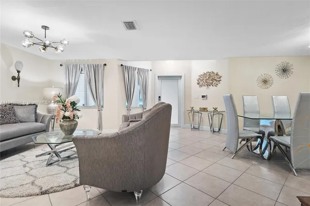 a living room with furniture and a chandelier