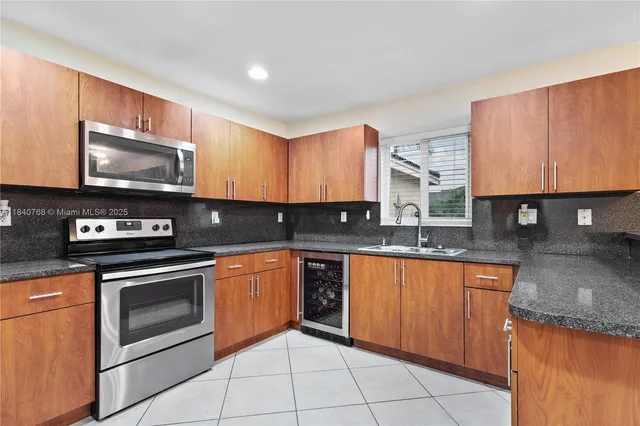 a kitchen with stainless steel appliances granite countertop a stove a sink and a microwave