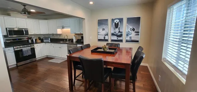 a kitchen with a table chairs microwave and cabinets