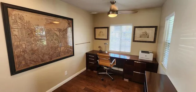 a view of a workspace with furniture and a window