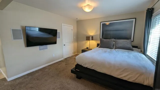 a bedroom with a bed and a flat screen tv