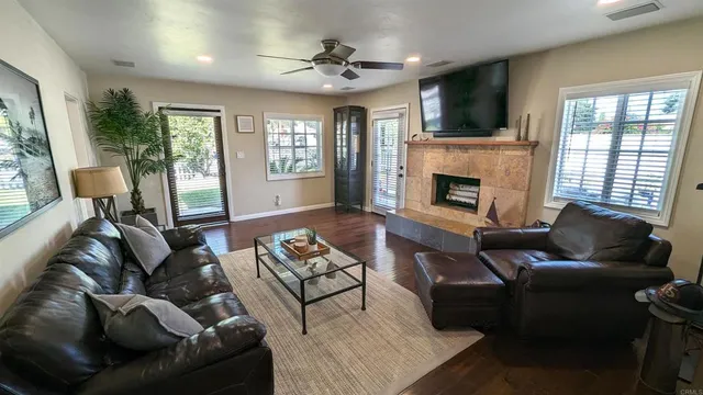 a living room with furniture a fireplace and a flat screen tv