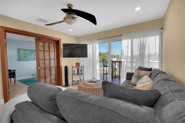 a living room with furniture and a ceiling fan