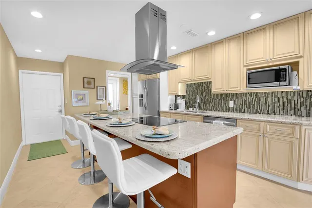 a kitchen with stainless steel appliances granite countertop a sink a stove and a wooden cabinets