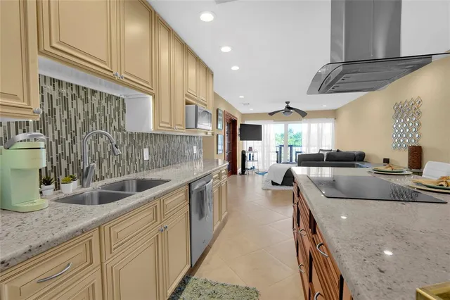 a kitchen with stainless steel appliances granite countertop a sink a refrigerator and a stove