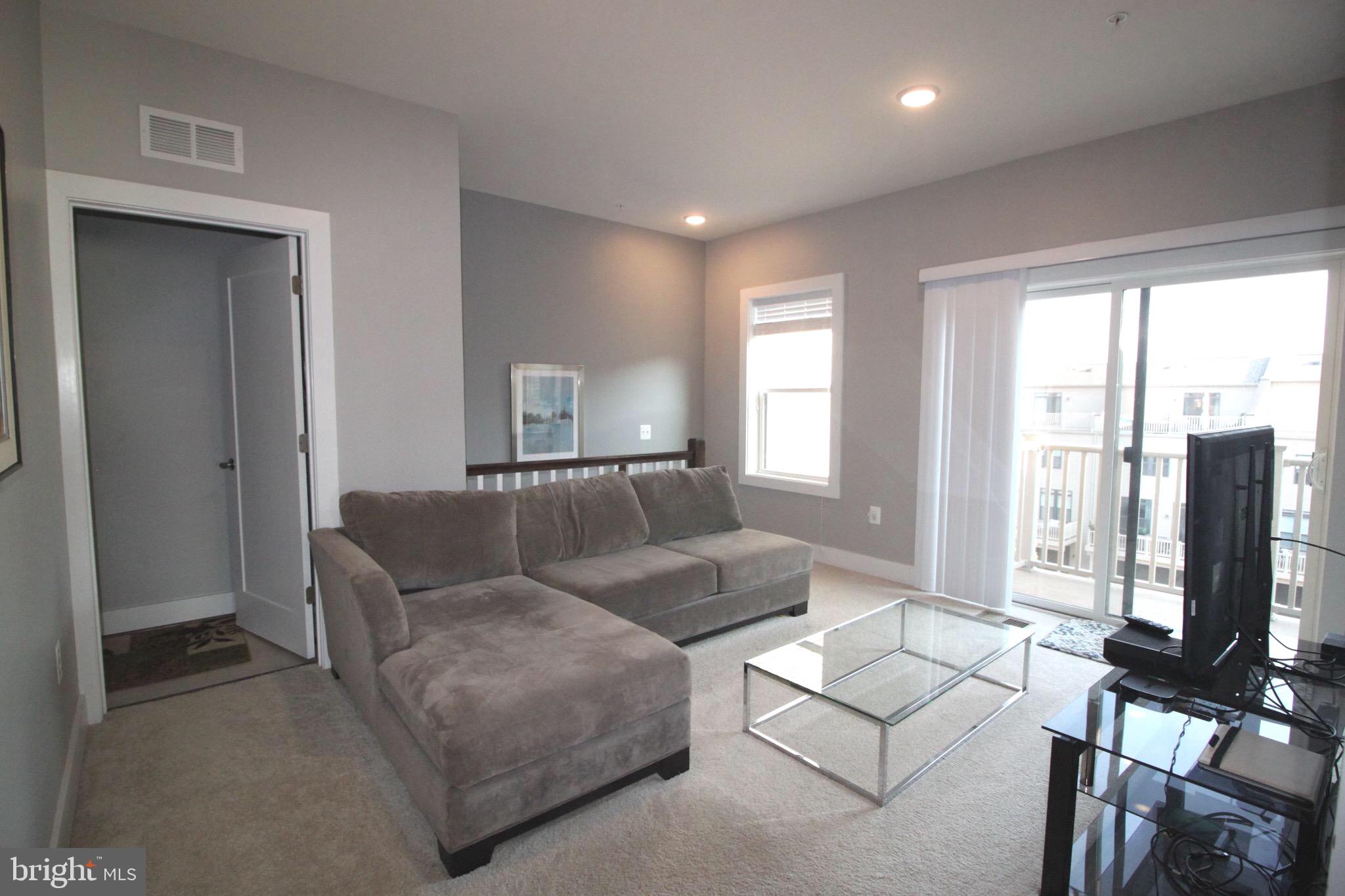 44738 Tiverton Square Ashburn, VA 20147 - Photo 11 of 66 a living room with furniture large windows and a flat screen tv