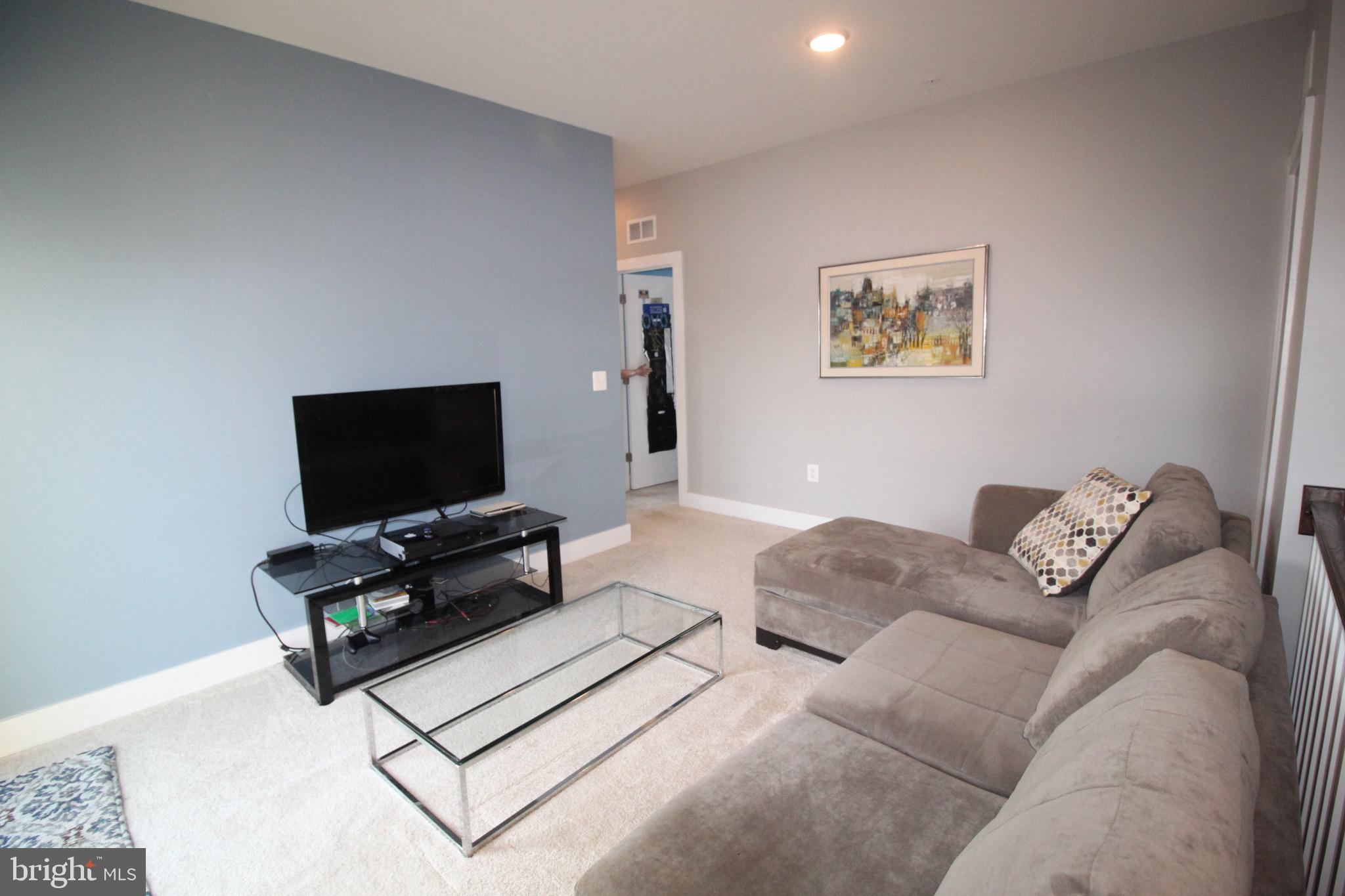 44738 Tiverton Square Ashburn, VA 20147 - Photo 30 of 66 a living room with furniture and a flat screen tv