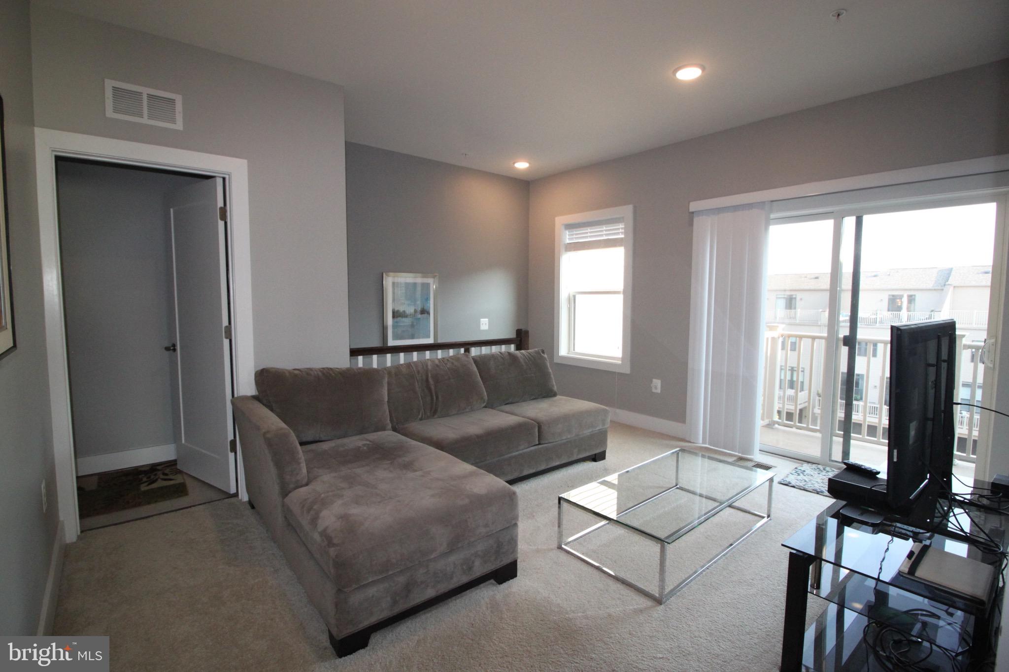 44738 Tiverton Square Ashburn, VA 20147 - Photo 33 of 66 a living room with furniture tv and a large window