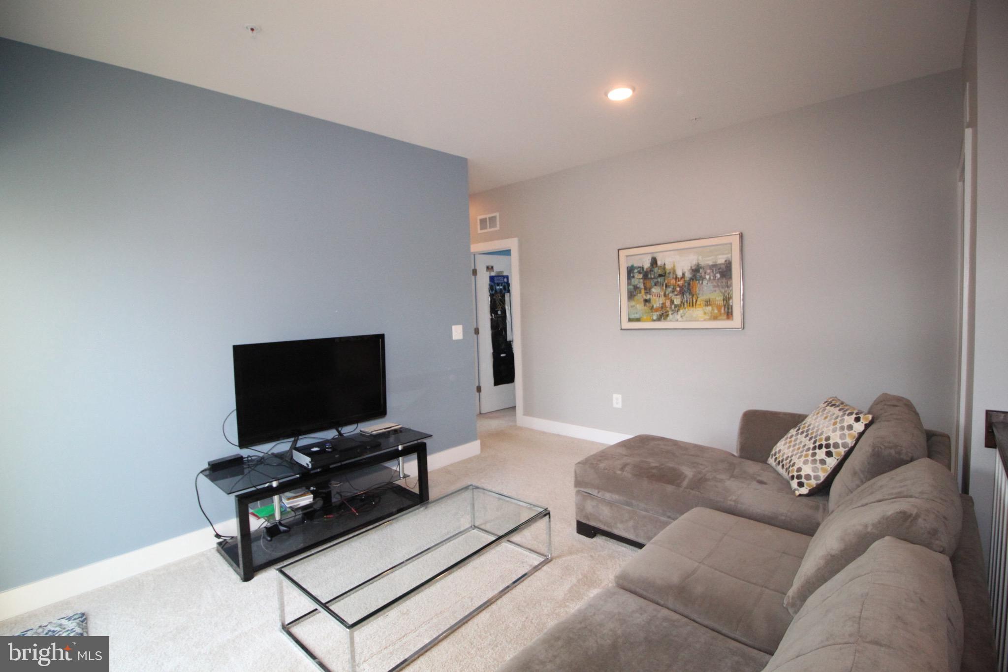 44738 Tiverton Square Ashburn, VA 20147 - Photo 34 of 66 a living room with furniture and a flat screen tv