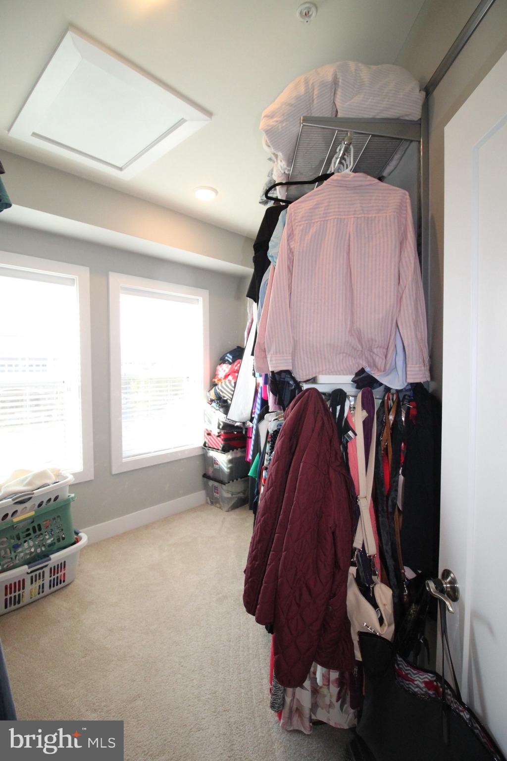 44738 Tiverton Square Ashburn, VA 20147 - Photo 47 of 66 a view of walk in closet with clothes and shoes
