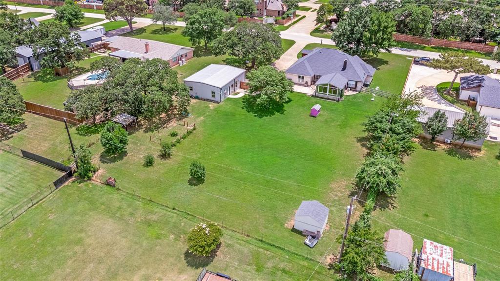 5643 West Caylor Road Fort Worth, TX 76244 - Photo 37 of 37 Expansive green acreage featuring a main residence with a dark shingle roof, an additional detached building, a swimming pool, and mature trees