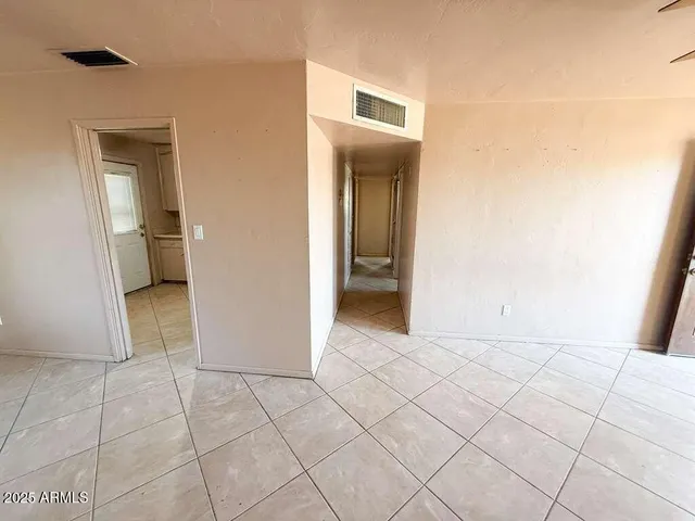 an empty room with a chandelier fan and closet