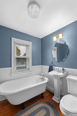 a bathroom with a bathtub sink mirror and toilet
