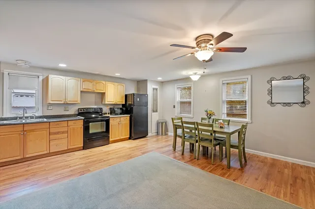 a view of a dining room with furniture a kitchen and chandelier