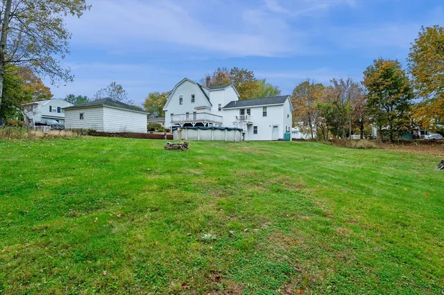 a view of a big house with a big yard and large trees