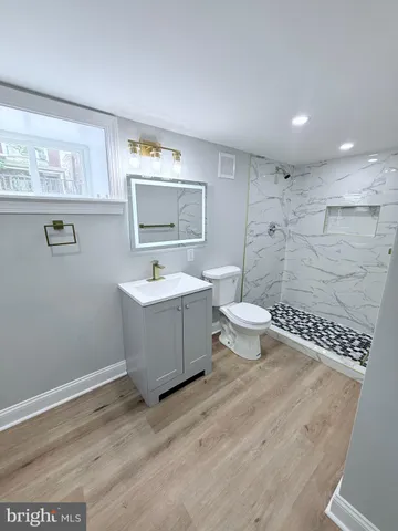 a bathroom with a sink a toilet a mirror and bathtub