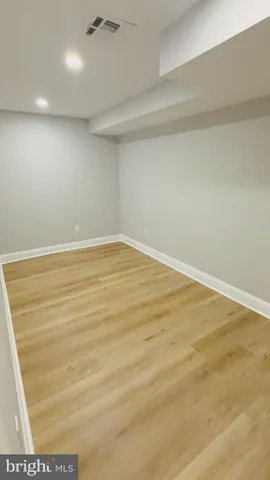 a view of white cabinets with a sink and wooden floor