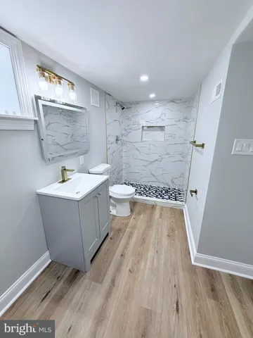 a bathroom with a sink a toilet and a mirror