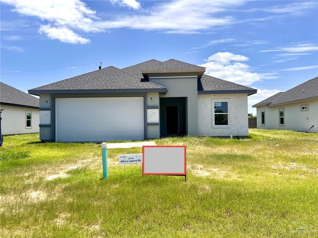 View of front facade with a garage, a shingled roof, and stucco siding