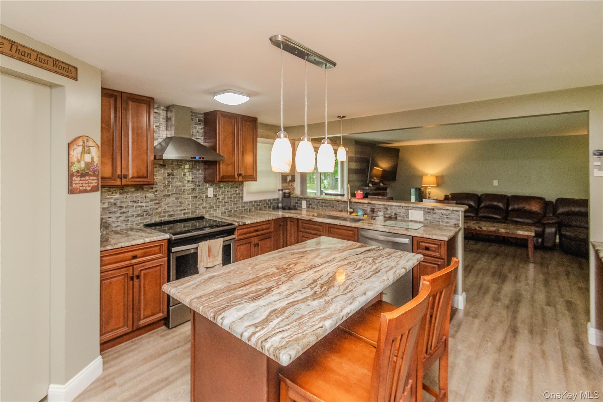 15 Van Dewark Road Middletown, NY 10941 - Photo 7 of 41 Kitchen featuring a large island with stone countertop, stainless steel appliances, stone tile backsplash, wood-finish flooring, and recessed lighting