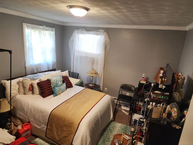 a bedroom with a bed gym equipment and window