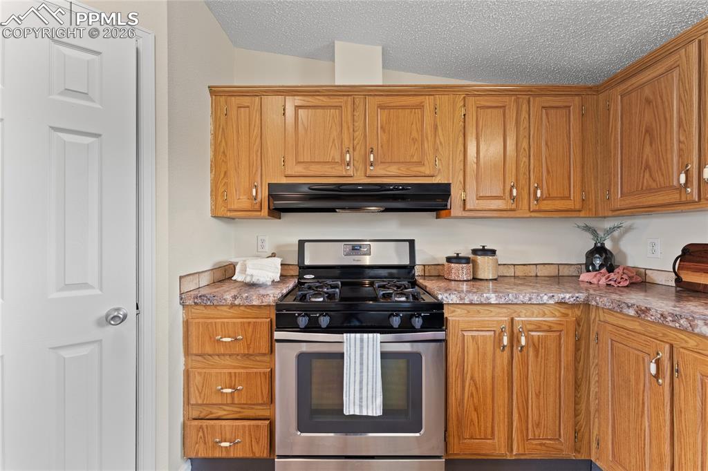 5505 Whipshaw Road Peyton, CO 80831 - Photo 11 of 39 a kitchen with granite countertop a stove sink and cabinets